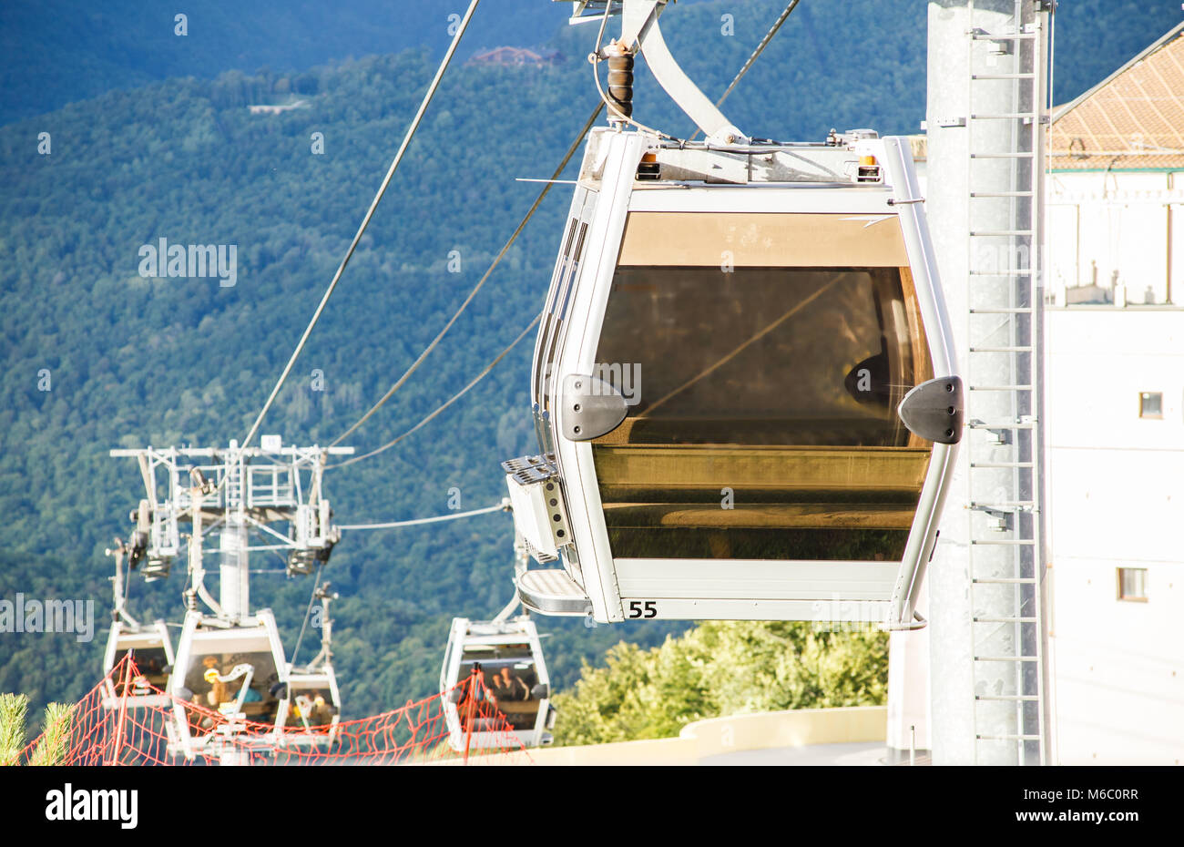 Photo of cable car cabins against backdrop of mountain slope during day ...