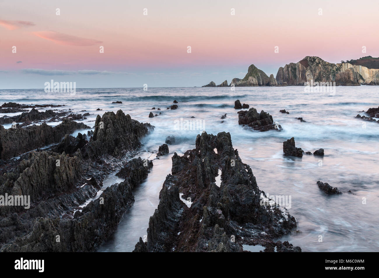 https://c8.alamy.com/comp/M6C0WM/the-beach-of-gueirua-a-disturbing-landscape-of-sharp-rocks-that-emerge-M6C0WM.jpg