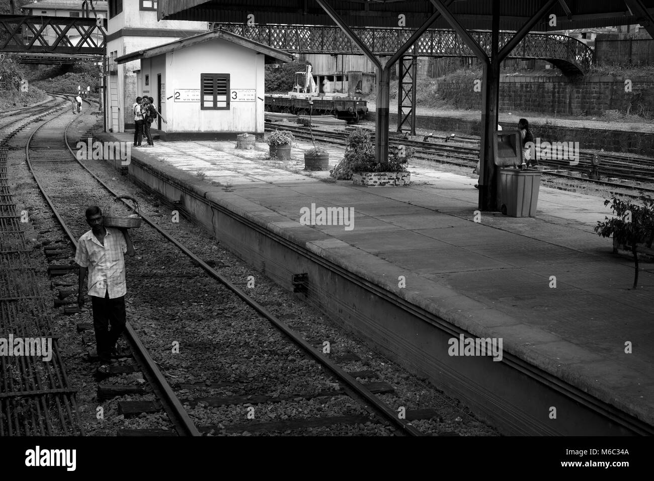 A man selling snacks walks down the railway tracks at Hatton station in the Badulla district of Sri Lanka Stock Photo