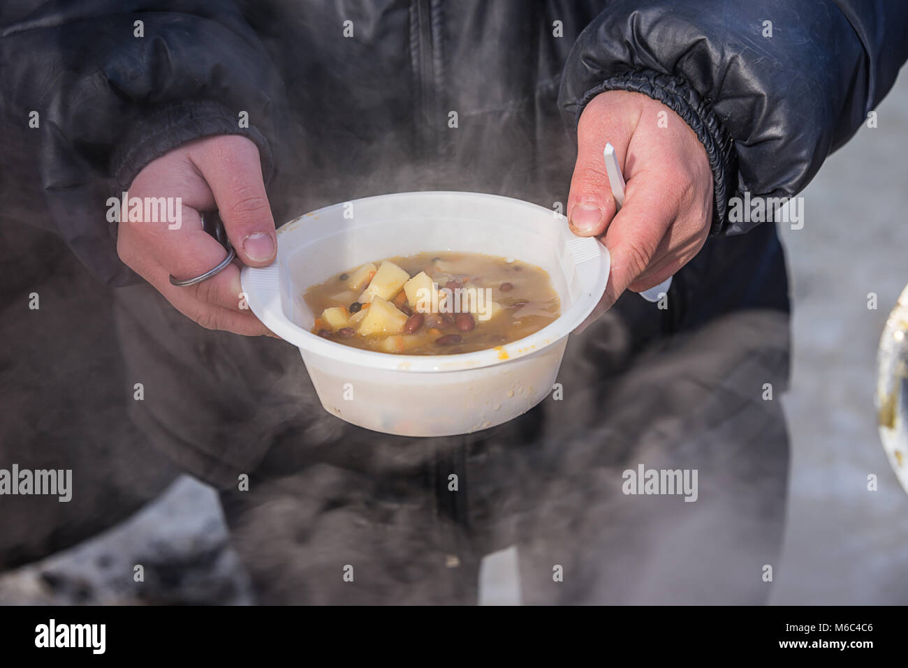 feeding homeless people on the street, social problems, hungry people eat Stock Photo