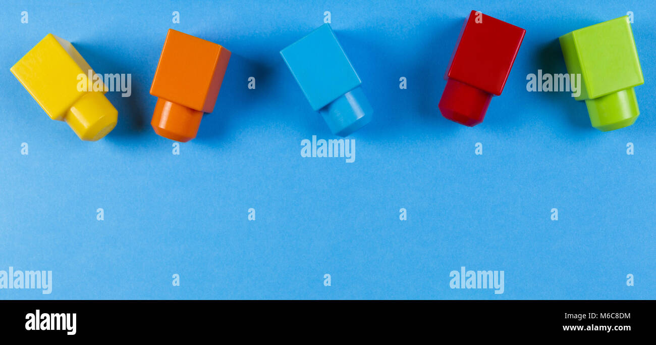 Colorful plastic construction blocks on blue background Stock Photo - Alamy