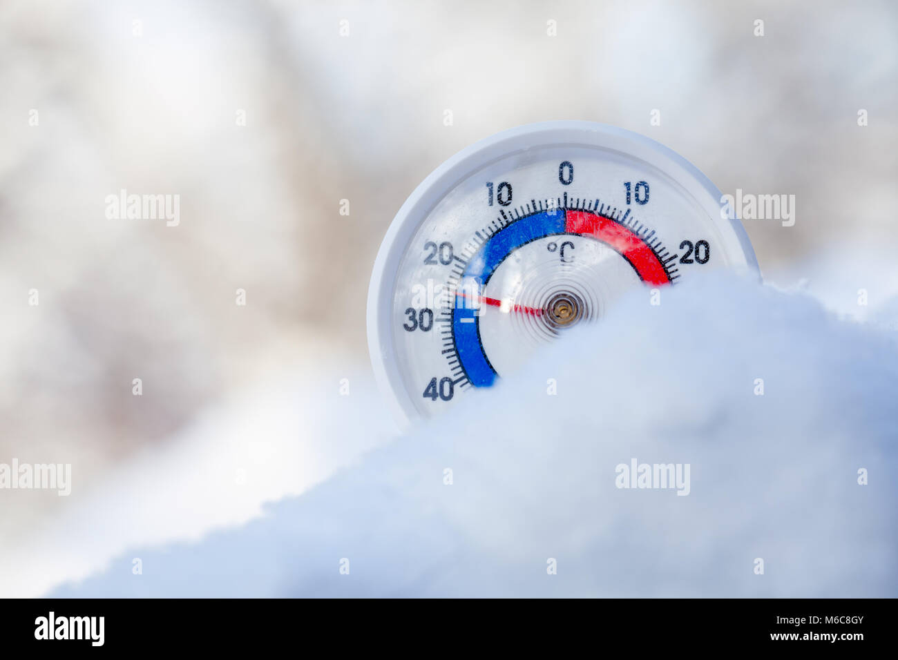 Thermometer with celsius scale placed in a fresh snow showing subzero