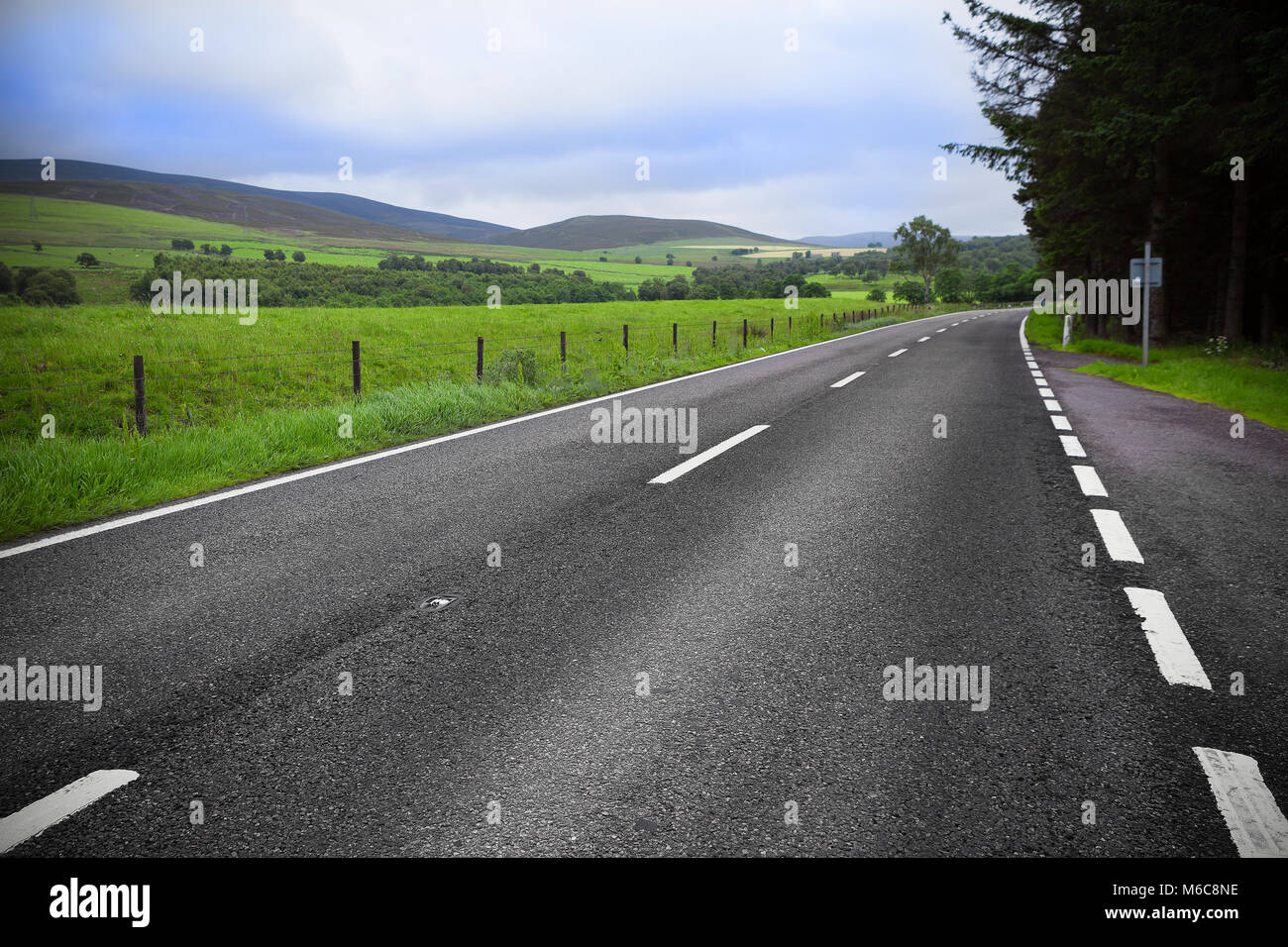 Asphalt road through the green field and clouds on blue sky Stock Photo ...