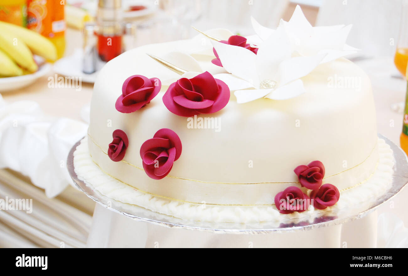 Picture of a White wedding cake with red roses Stock Photo