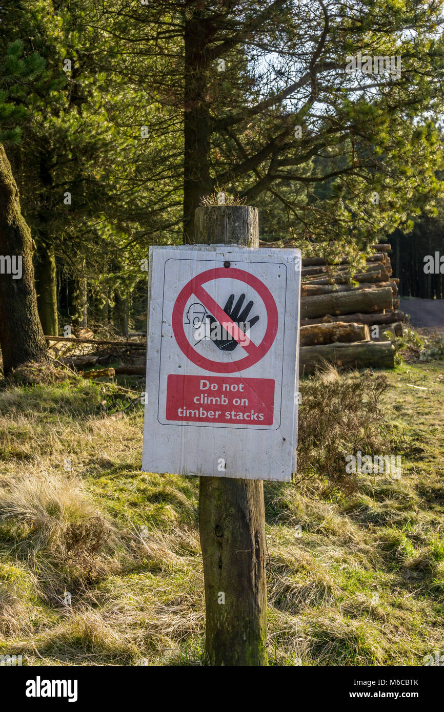 Do not climb on timber stacks, warning sign in woodland near Holme