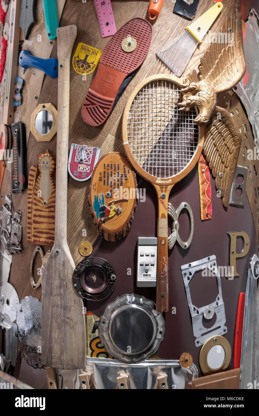 An art collage of home items arranged and stapled to a wall post. Stock Photo