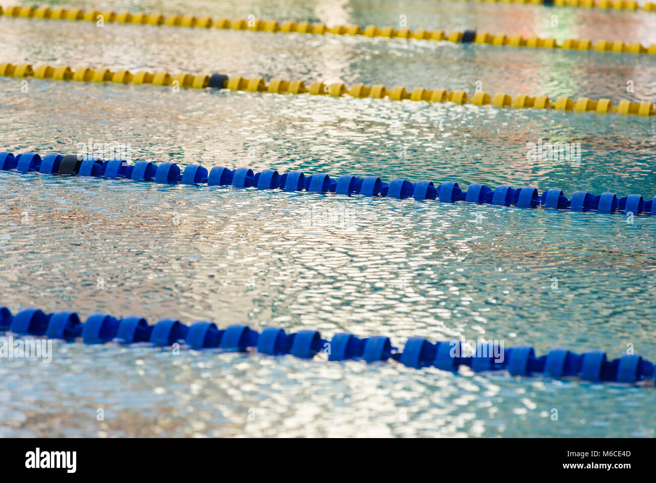 An empty outdoor olympic swimming pool with swimming lanes divided by floatation devices Stock Photo