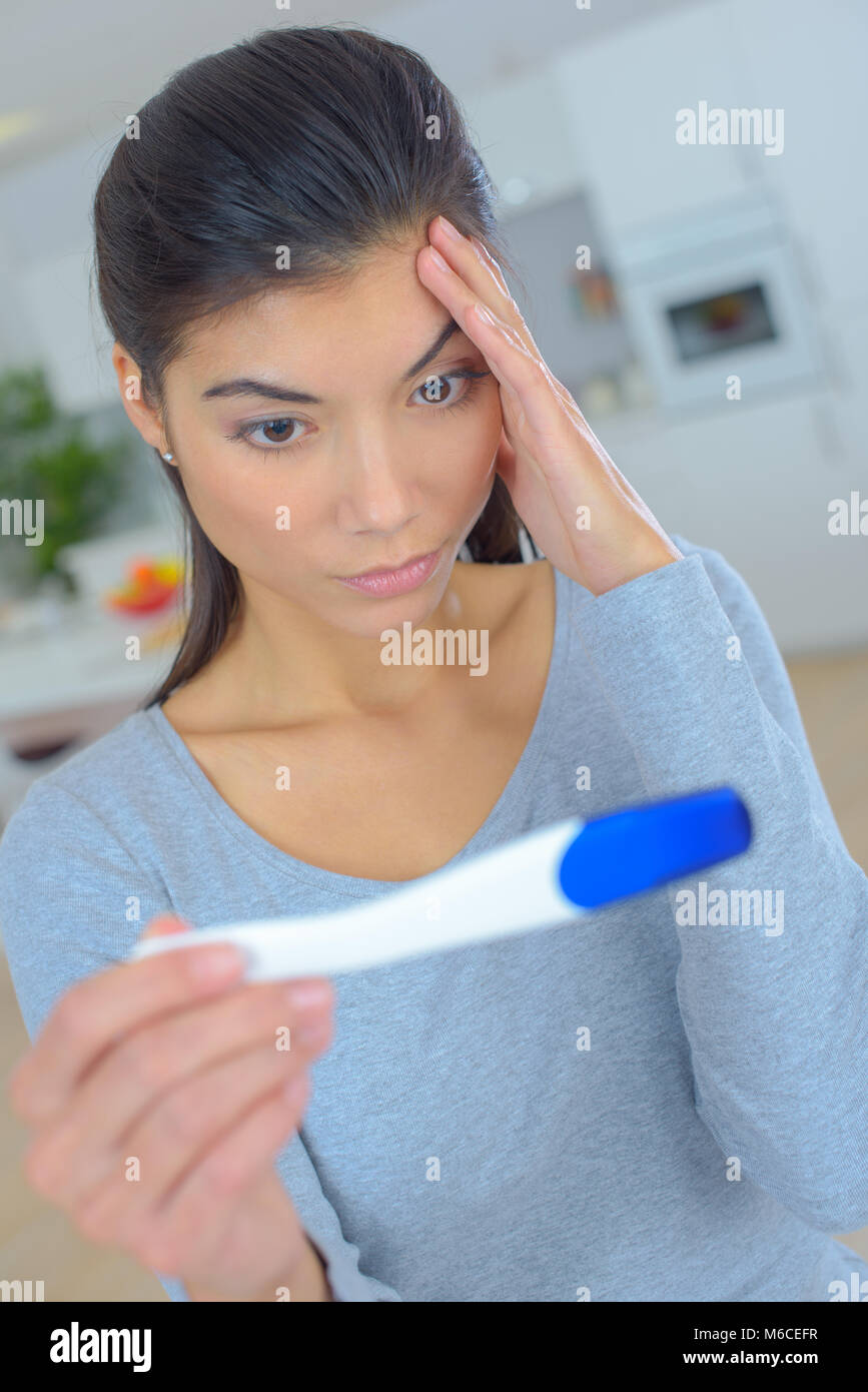stressed woman looking on pregnancy test Stock Photo - Alamy