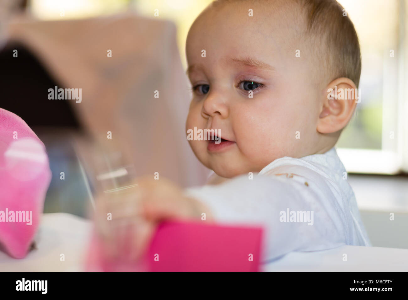Cute baby girl, 10 months old, slapping with her arm Stock Photo