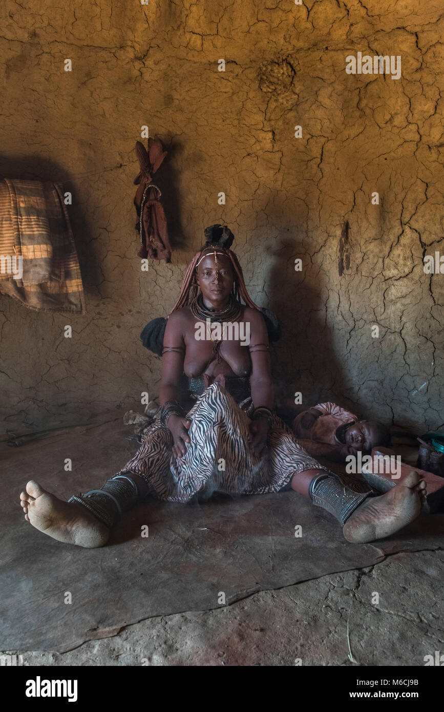 Woman of the Ovahimba or Himba people cleaning and disinfecting clothes and body, Kunene district, Namibia Stock Photo