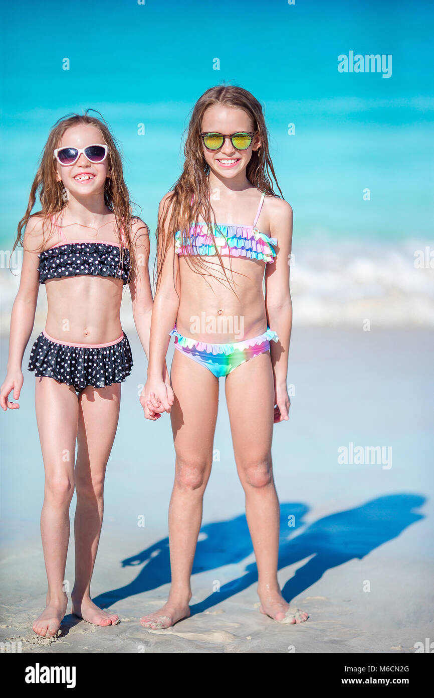 Adorable little girls have a lot of fun on the beach. Two ...