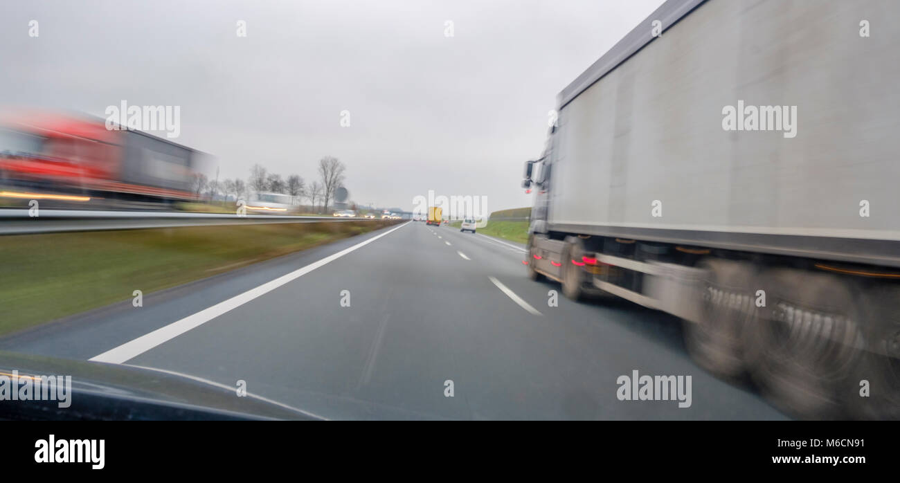 lorries overtaking at high speed on the highway, with movement Stock Photo