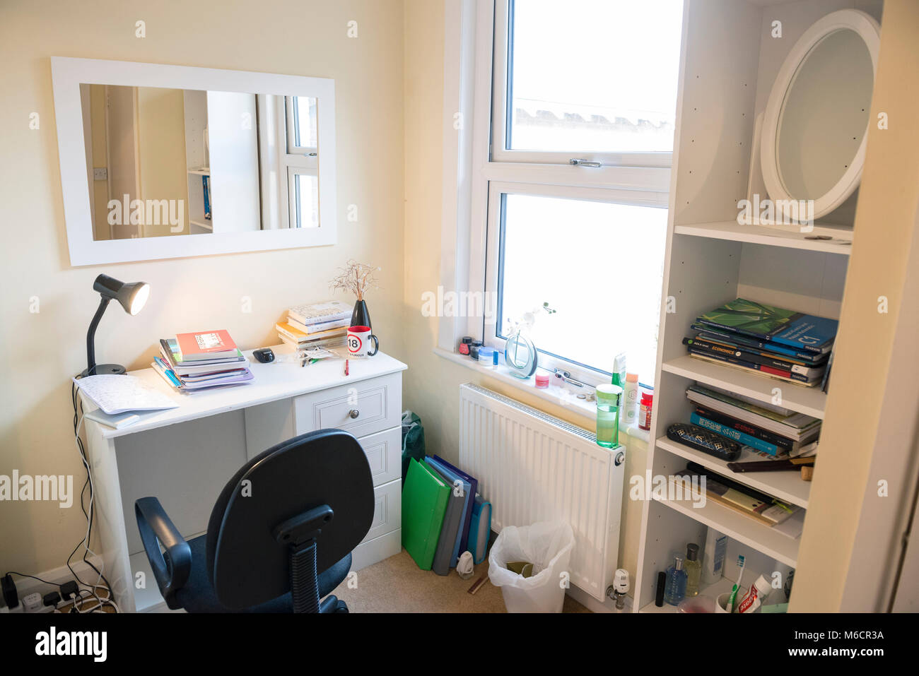 students bedrooms in a student let house while they are staying with the homeowner, showing the bed and desk areas Stock Photo