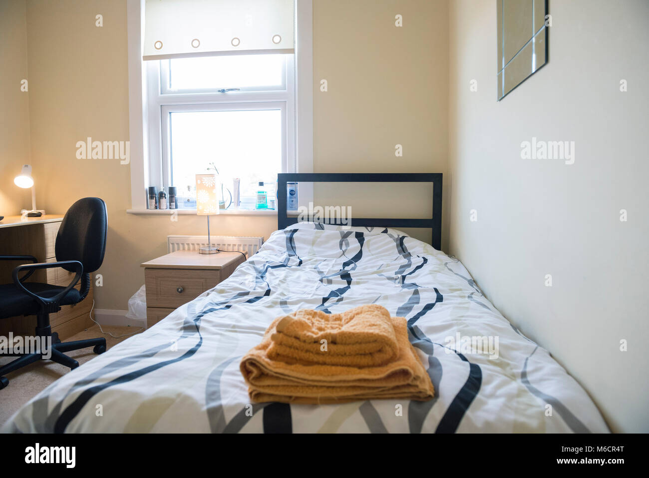 students bedrooms in a student let house while they are staying with the homeowner, showing the bed and desk areas Stock Photo