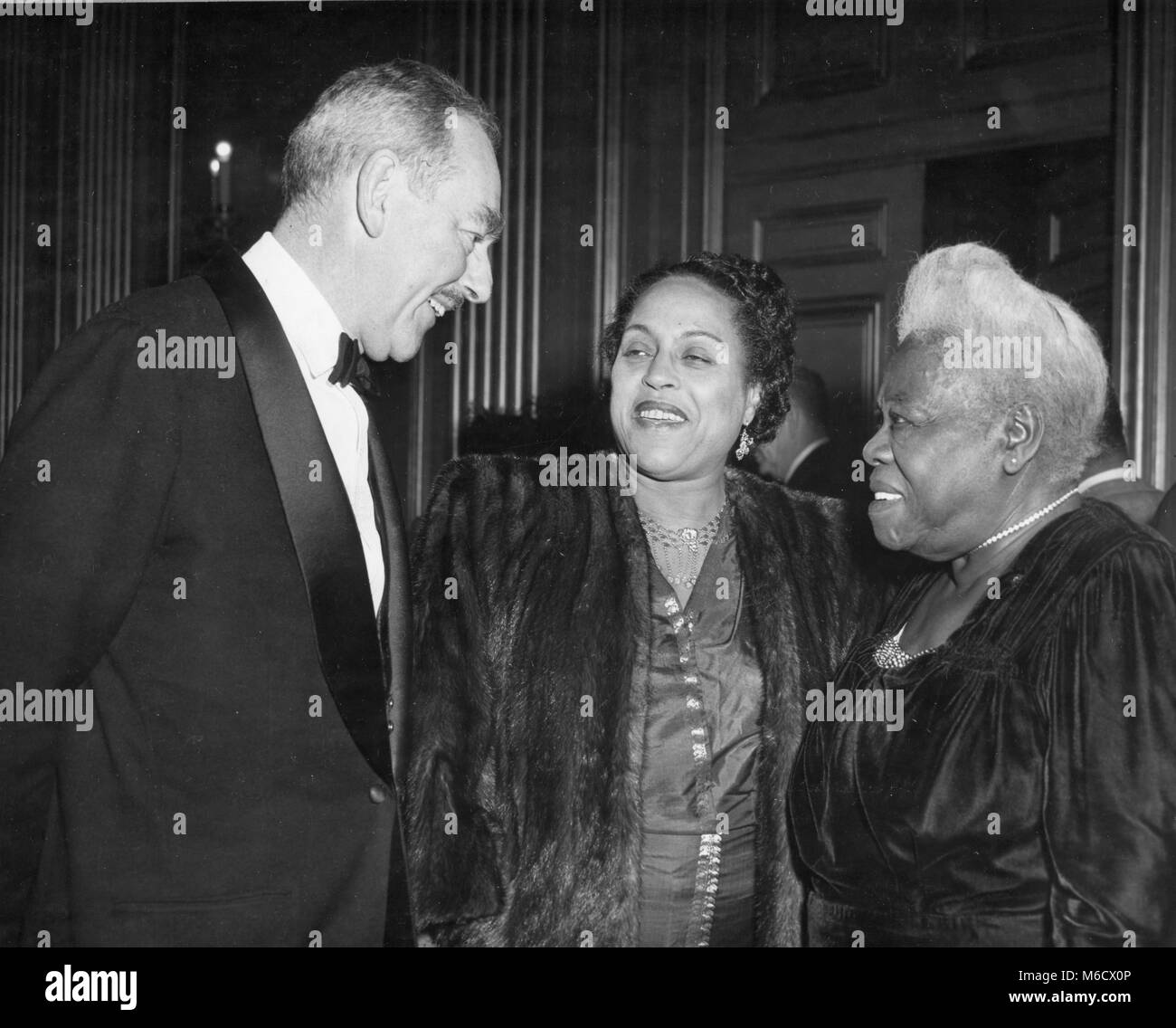 Secretary of State Dean Acheson (left) is shown at the 15th annual convention of the National Council of Negro Women, talking to Mrs. Edith S. Sampson (center) and Mary McLeod Bethune, founder of the Council. Washington, DC, 11/50. Stock Photo