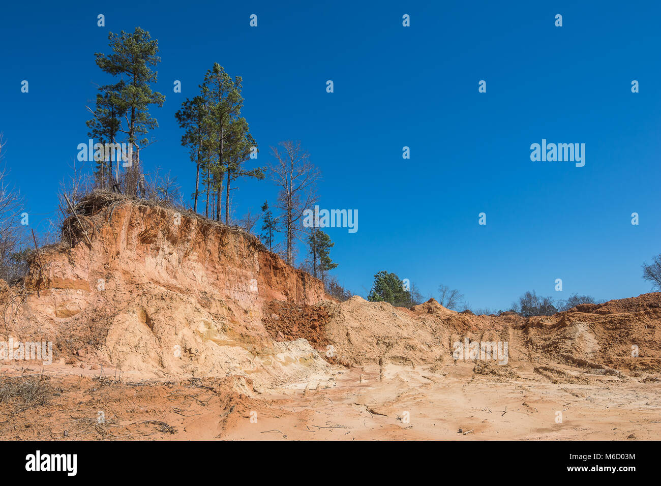 A nearly demolished hill of red clay dirt. It is used for road work and