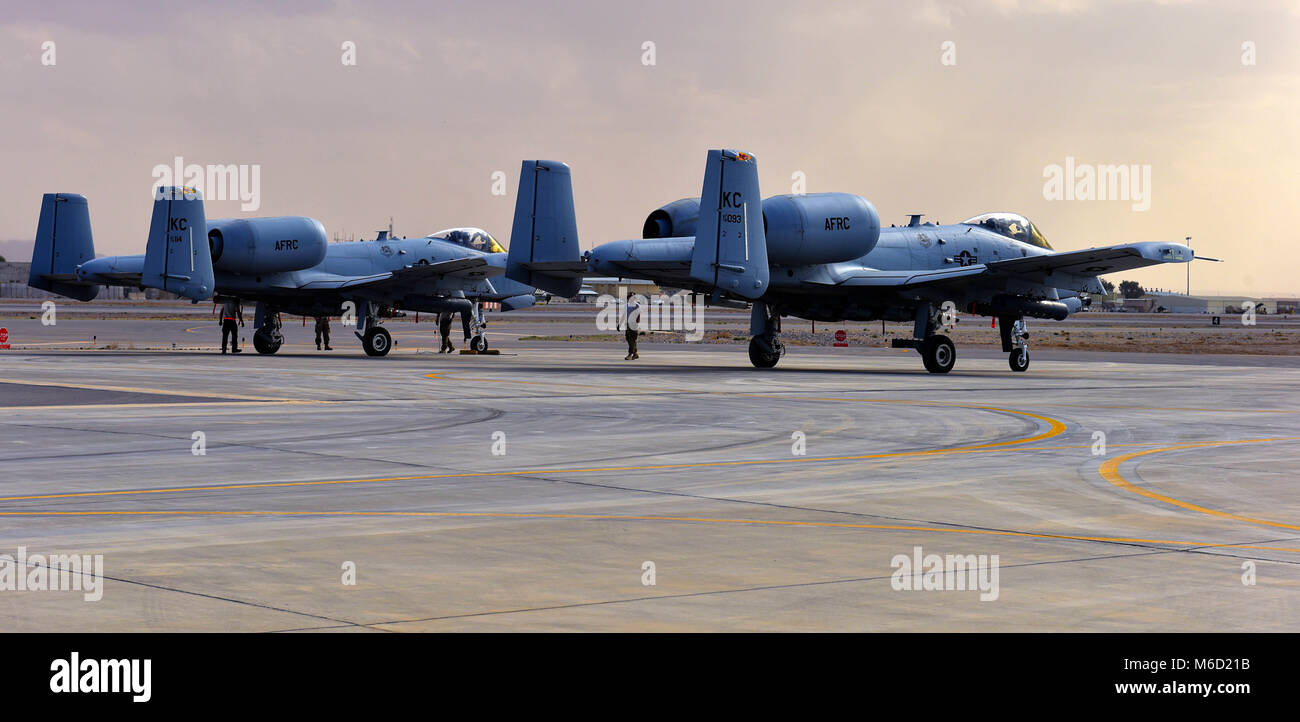 Crew chiefs and weapons Airmen assigned to the 303rd Expeditionary Fighter Squadron arm the weapons on two A-10 Thunderbolt IIs prior to takeoff at Kandahar Airfield, Afghanistan, Feb. 27, 2018. Arming weapons is the final task for maintenance Airmen to complete before the aircraft take off. (U.S. Air Force photo by Staff Sgt. Trevor Rhynes) Stock Photo