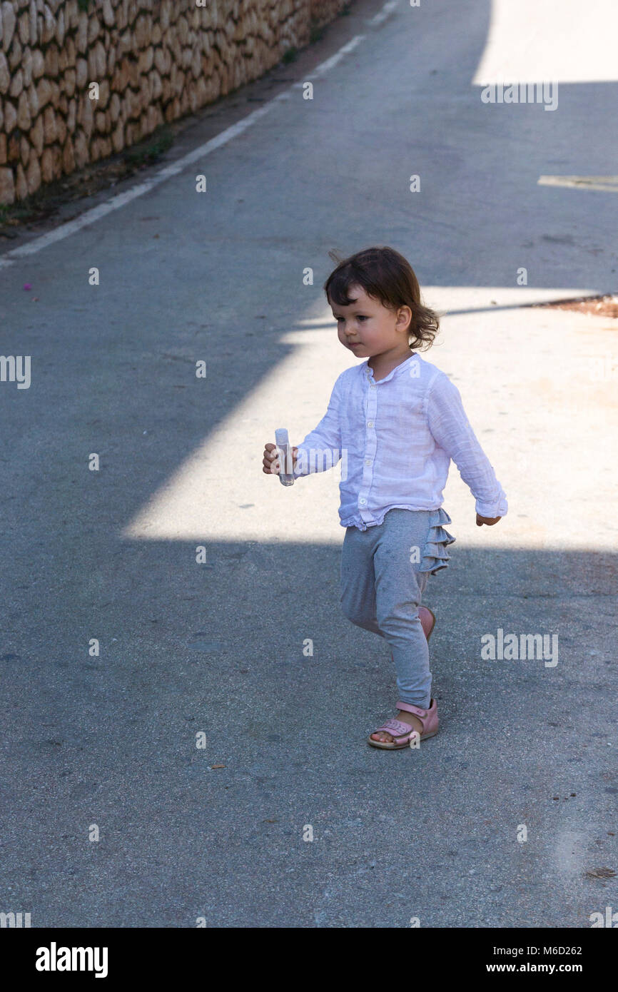 Toddler walking on the street Stock Photo