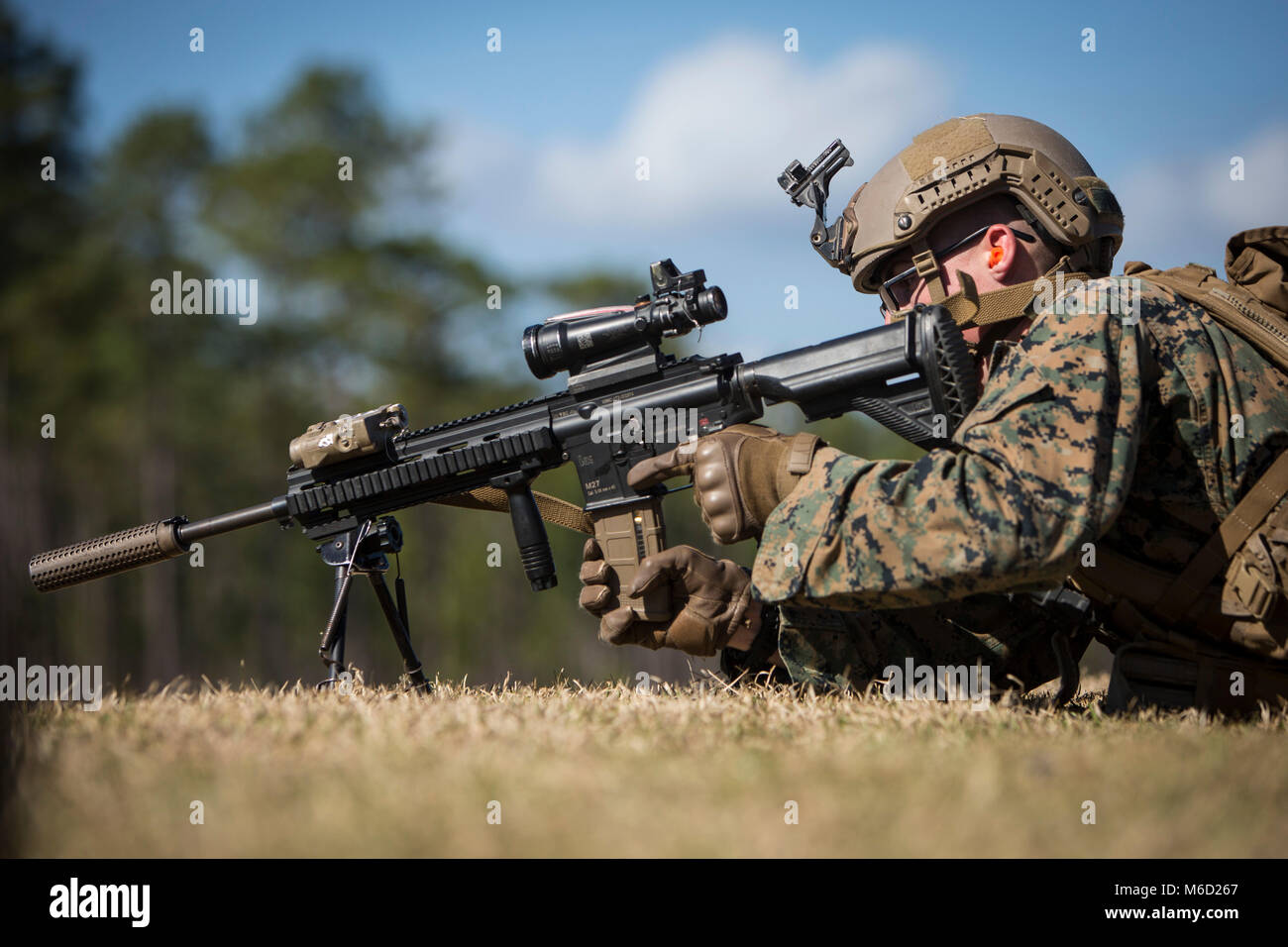 U.S. Marine Corps Lance Cpl. Albert Bridges, a rifleman with 3rd Battalion, 6th Marine Regiment, 2nd Marine Division (2d MARDIV), inserts a magazine into an M-27 Infantry Assault Rifle while conducting a Table-3 Live Fire 3 Exercise during the 2d MARDIV Infantry Squad Movement Evaluation (ISME) on Camp Lejeune, N.C., Feb. 21, 2018. The 2d MARDIV ISME evaluates the tactical proficiency of infantry rifle squads and determine, under simulated combat conditions, the Division’s most proficient and capable squad. The competition is designed to emphasize the correct conduct of tactics, techniques, pr Stock Photo