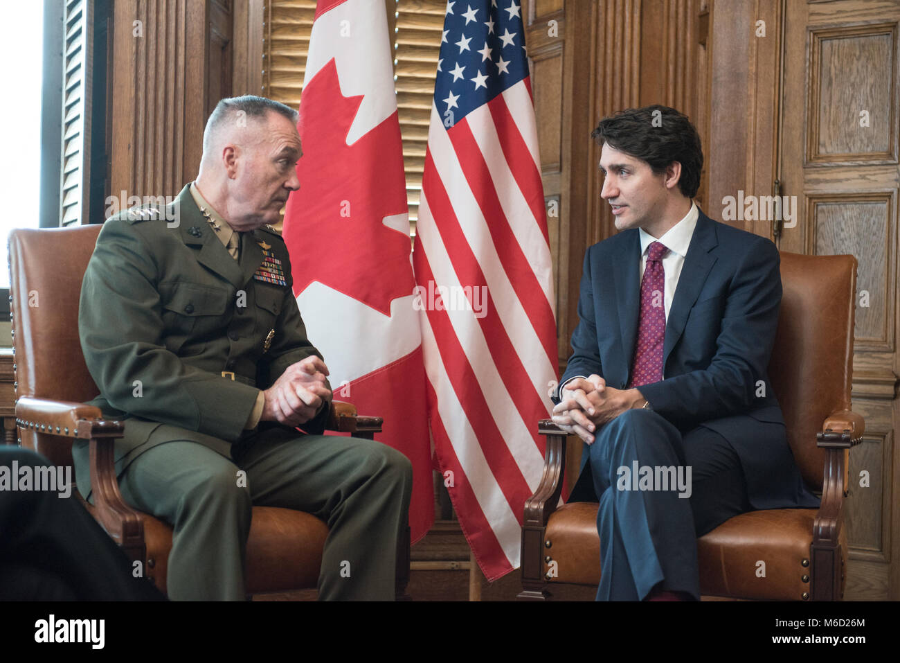 U.S. Marine Corps Gen. Joe Dunford, chairman of the Joint Chiefs of Staff, speaks with Justin Trudeau, Prime Minister of Canada, in the Canadian Parliament buildings, Ottawa, Canada, Feb. 28, 2018. Gen. Dunford was in Ottawa for meetings with senior Canadian officials on the ongoing evolution of the North American Aerospace Defense Command. (DoD Photo by U.S. Army Sgt. James K. McCann) Stock Photo