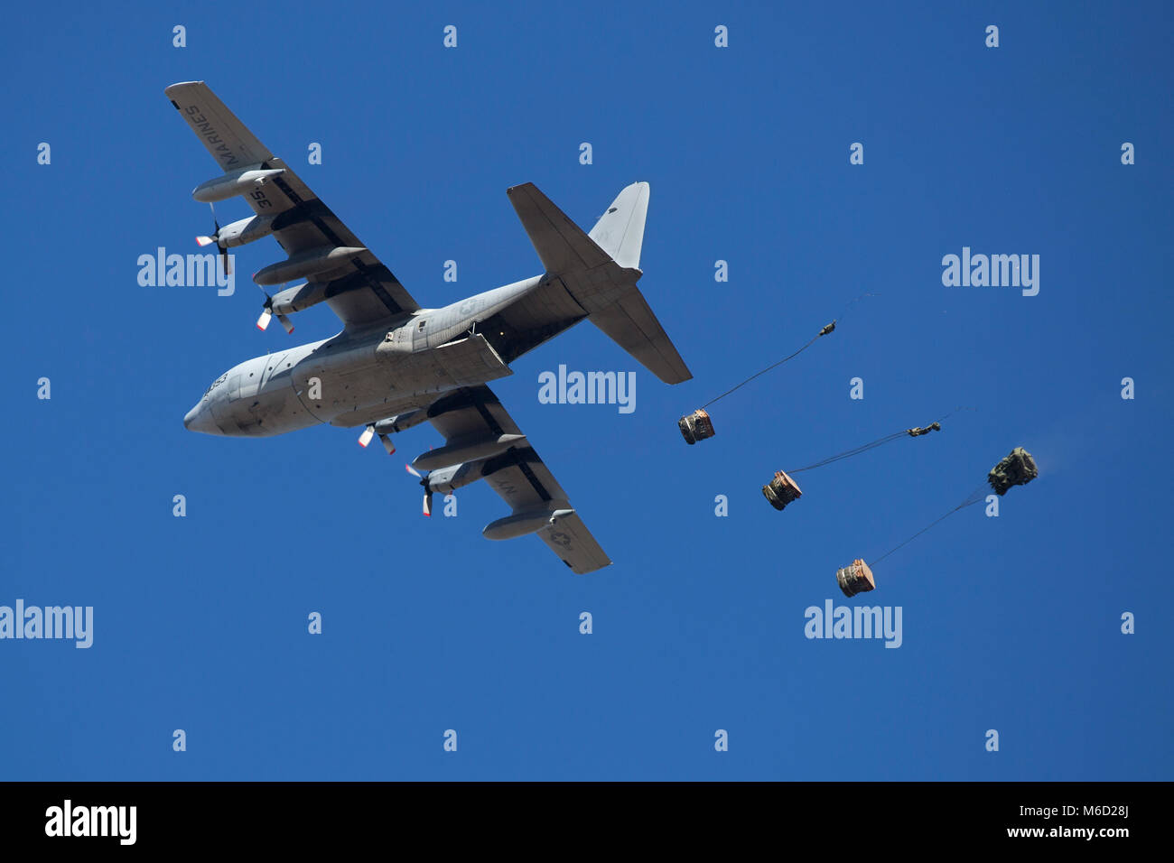 A KC-130T from Marine Aerial Refueler Transport Squadron 452 drops cargo as part of container delivery system training at a drop zone on Camp Lejeune, N.C., Feb. 22, 2018. The training simulated transporting supplies, vehicles and Marines to a designated area. (U.S. Marine Corps photo by Lance Cpl. Ashley McLaughlin) Stock Photo