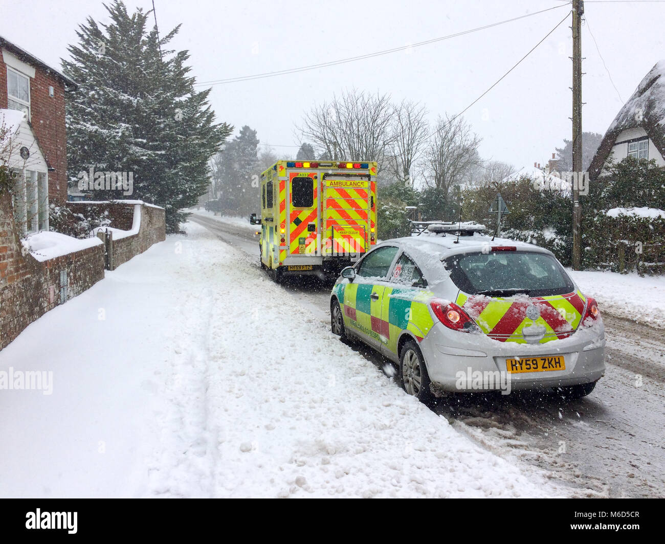 Paramedics and an ambulance in attention in a wintry scene with snow near the at Godshill near Fordingbridge on the New Forest, Hampshire, England, UK, in March 2018 during Storm Emma and the beast from the east. Stock Photo