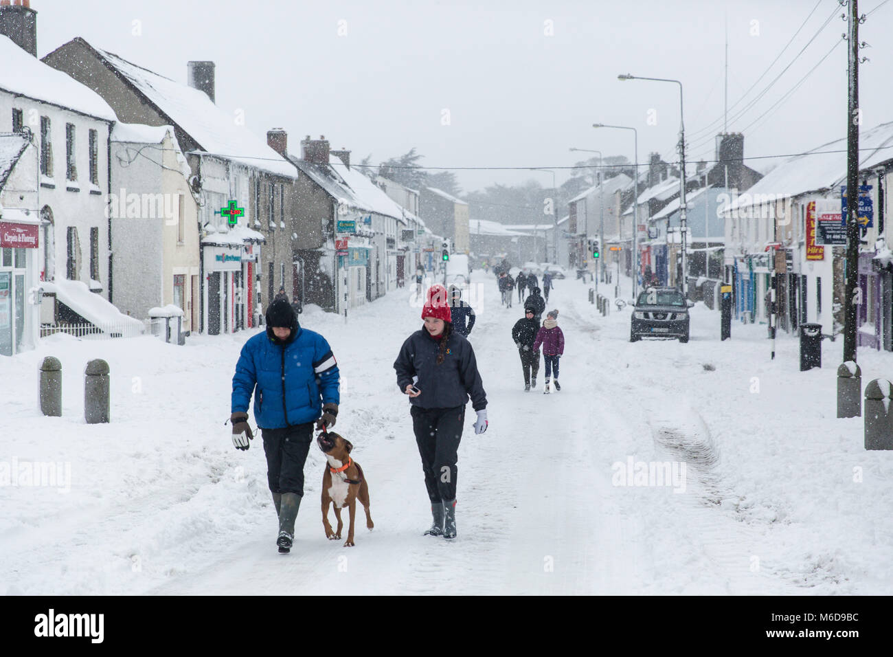 Celbridge, Kildare, Ireland. 02 Mar 2018: Main street in Celbridge covered in snow in the aftermath of the cold wave bugged "The Beast from The East" followed by Storm Emma. People out walking on the covered in snow road in Celbridge town. Winter scenery. Stock Photo