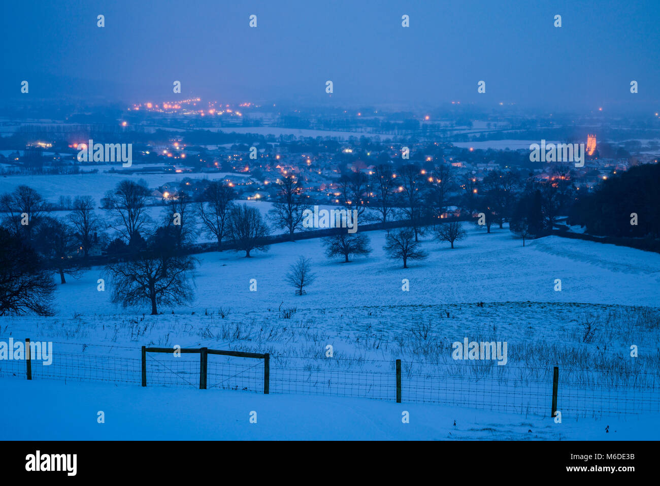 Nightfall over the village of Wrington after recent snowfall viewed from Old Hill, North Somerset, England. Stock Photo