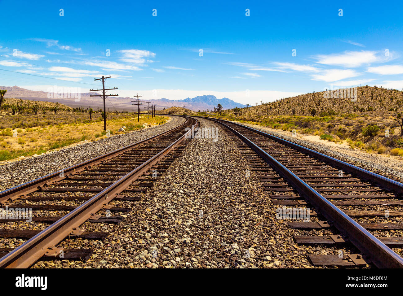 Railroad tracks going through Mojave Desert in California with beautiful view Stock Photo