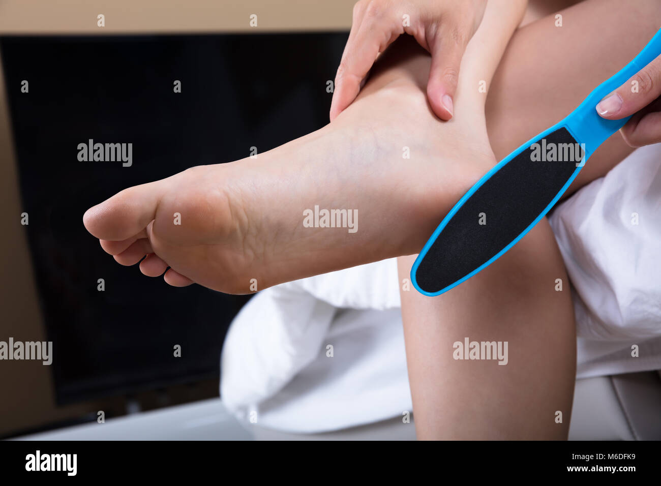 Close-up Of Woman Filling Foot With Foot File Stock Photo