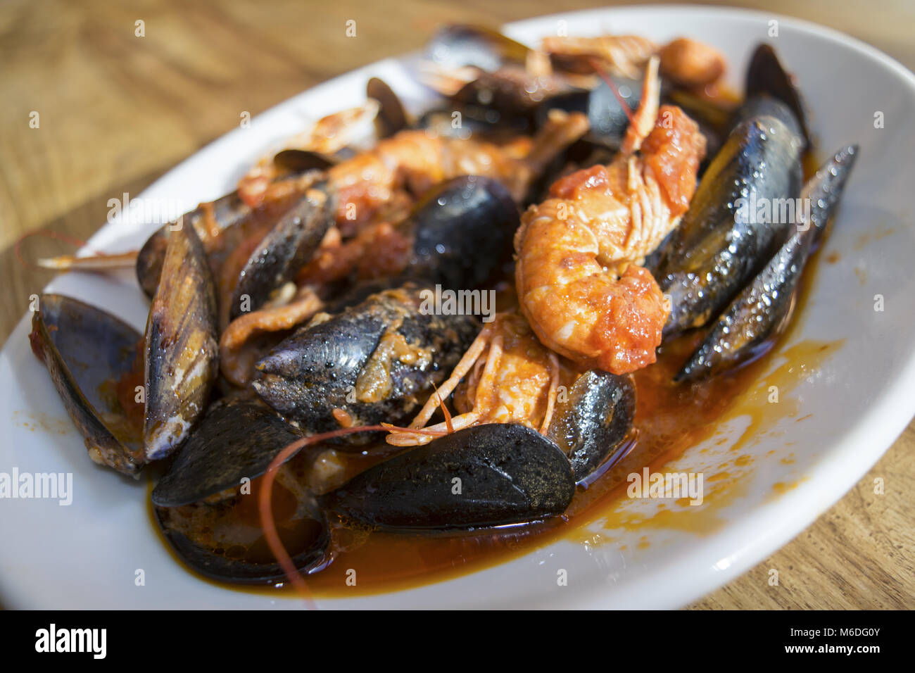 dish of seafood soup with mussels and crustaceans dressed with tomato sauce Stock Photo