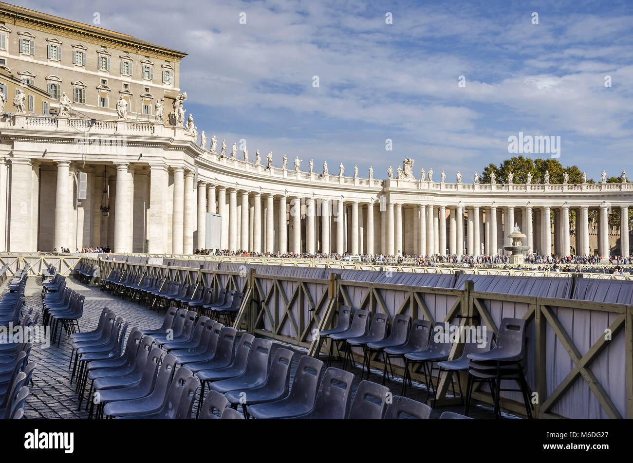 Vatican City, Vatican City State - November 5, 2015:  Tuscan colonnades of  St.Peter's Square with a lot of seats prepared for catholic believers Stock Photo