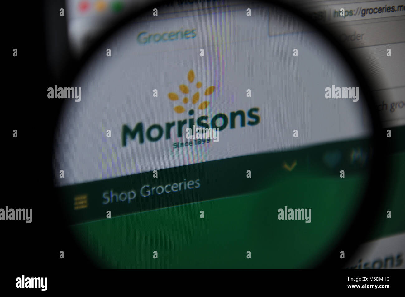 Morrisons website seen through a magnifying glass Stock Photo
