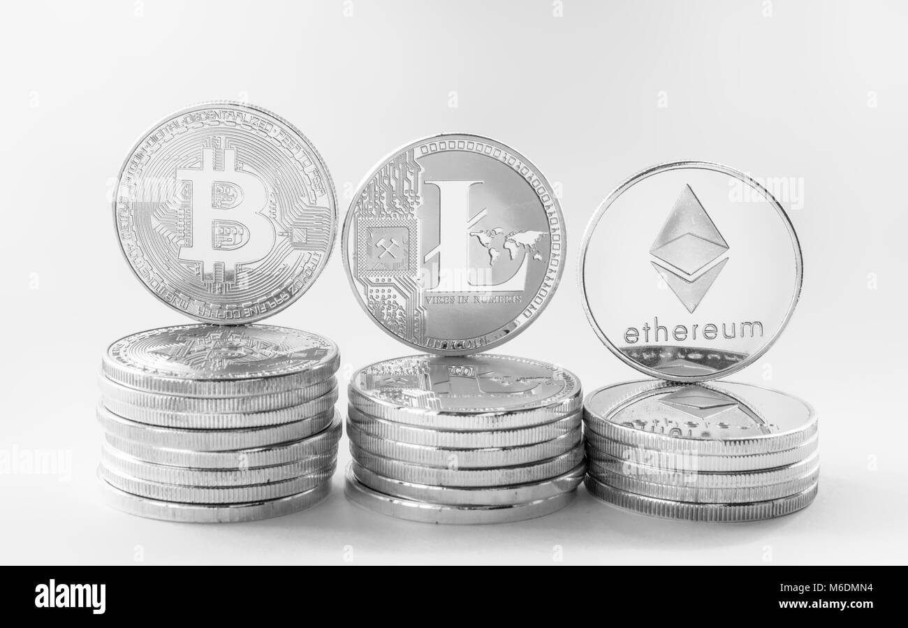 Silver coins of a digital crypto currency - litecoin bitcoin ethereum. The coins stand on steps created with lying coins of the same value. White back Stock Photo
