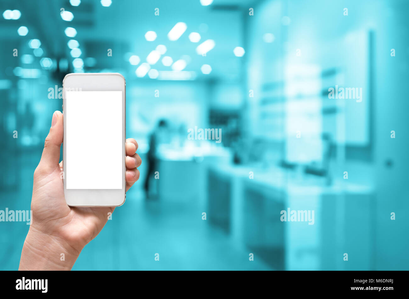 Female hand holding mobile smart phone on store blur with bokeh ...