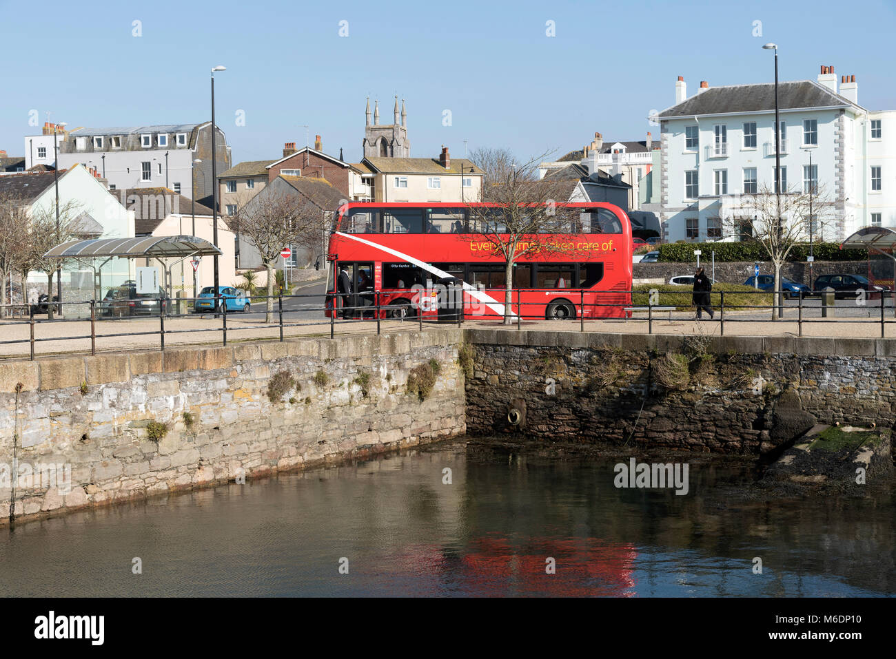Plymouth, Devon, England UK. February 2018. A red double decker bus on the waterfront at Royal William Yard Harbour Stock Photo
