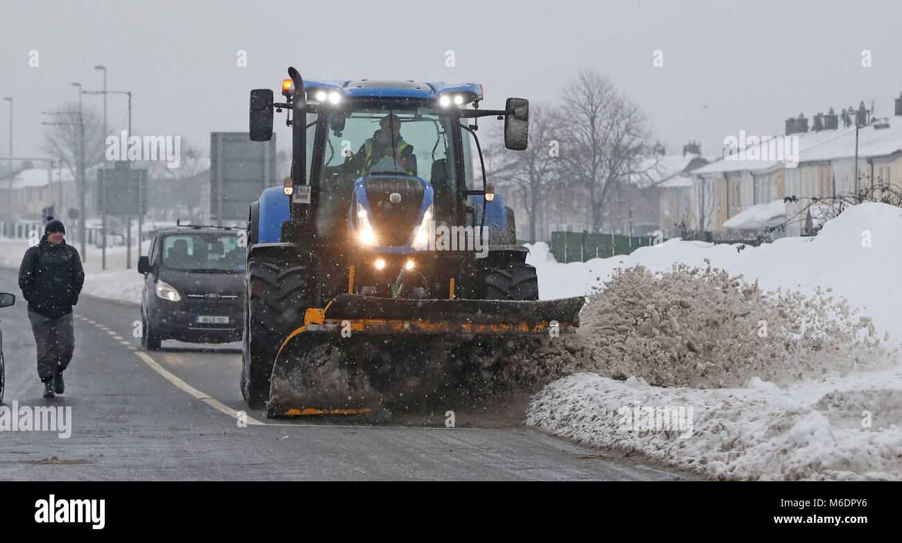 A snow plough clears roads in Tallaght, Dublin as a status orange weather alert remains in many counties in Ireland. Stock Photo