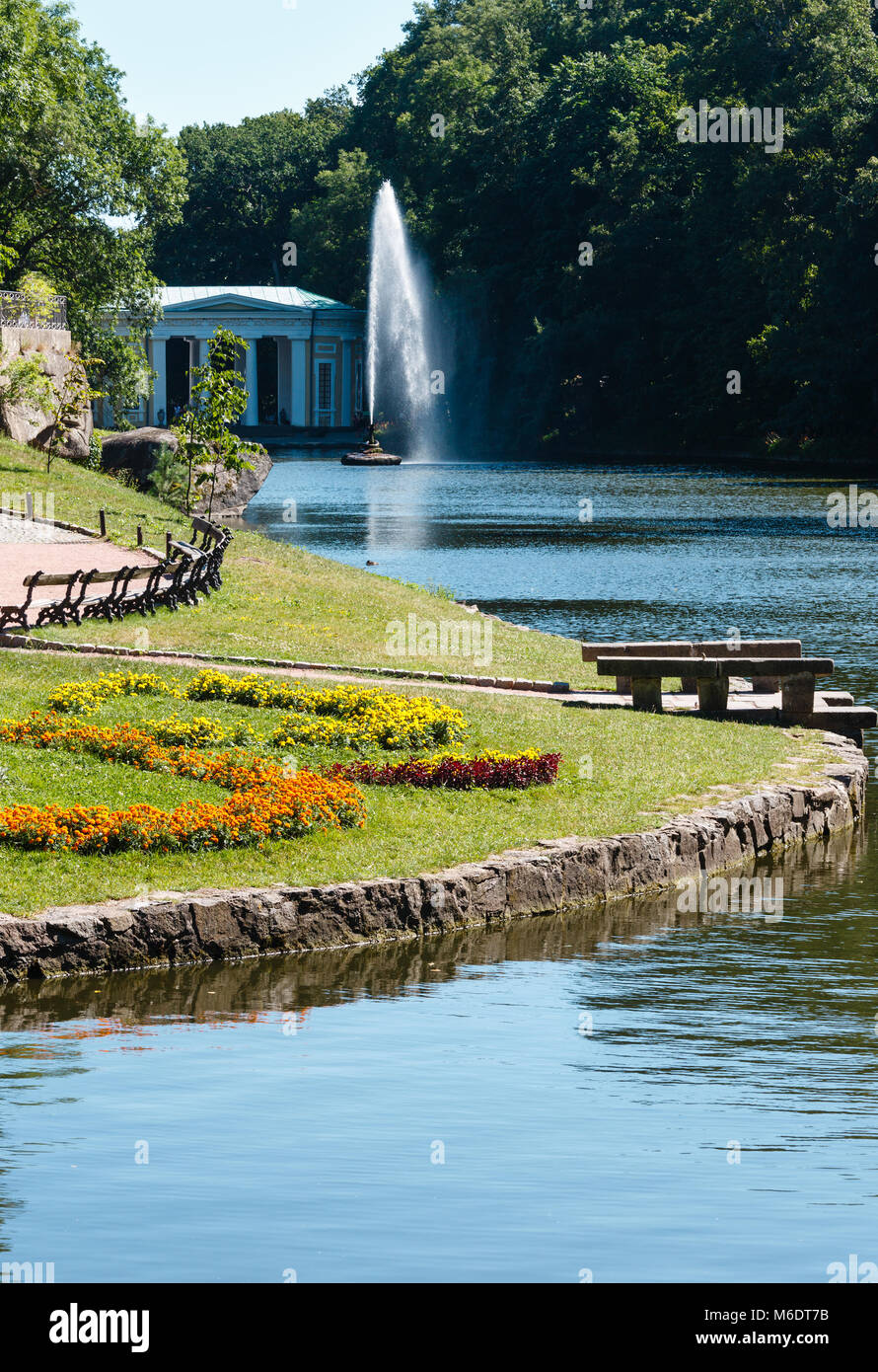 Summer National Dendrology Park of Sofiyivka, Fountain 'Snake', lake and flowerbed on lawn. Uman, Ukraine. Build in 19th century. People unrecognizabl Stock Photo