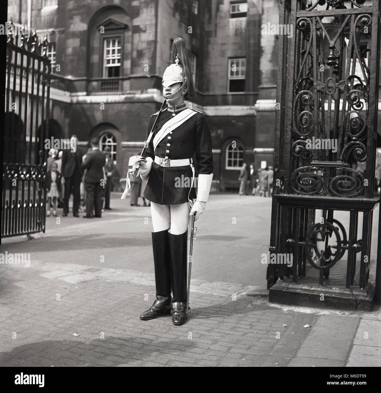 1960s, historical picture, a Queen's Life Guard from the Household Cavalry on sentry duty outside an open gated entrance at Whitehall, London, England, UK. Stock Photo