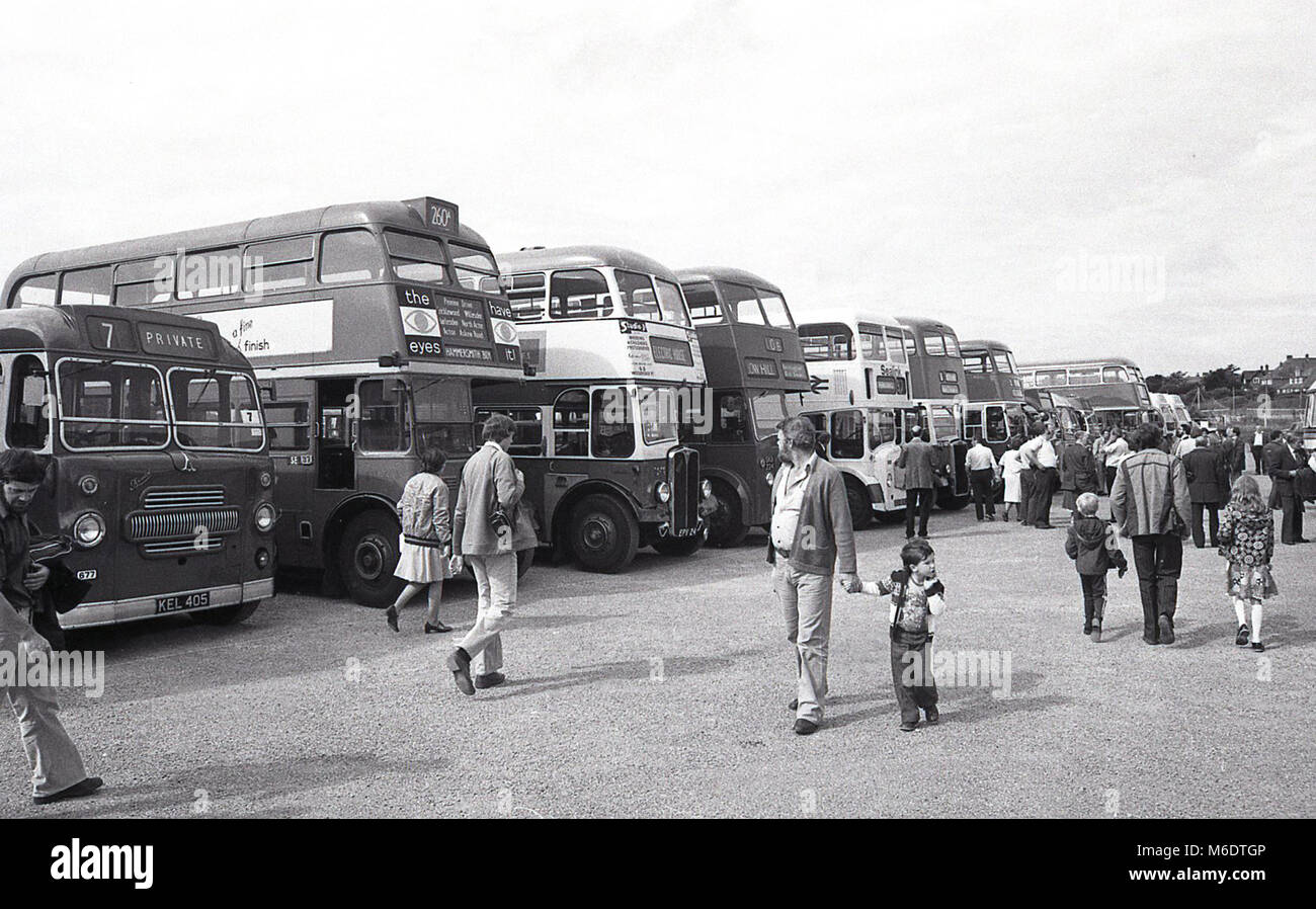 1970s, visitors on a family friendly day out wonder around seeing the vintage transport, such as restored buses and coaches, on display, England, UK. Stock Photo