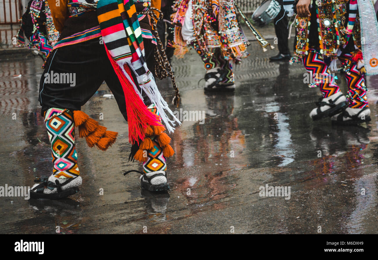 Indigenous dancers parade the rainy streets in a pre-carnival procession in Cochabamba, Bolivia in February 2018 Stock Photo
