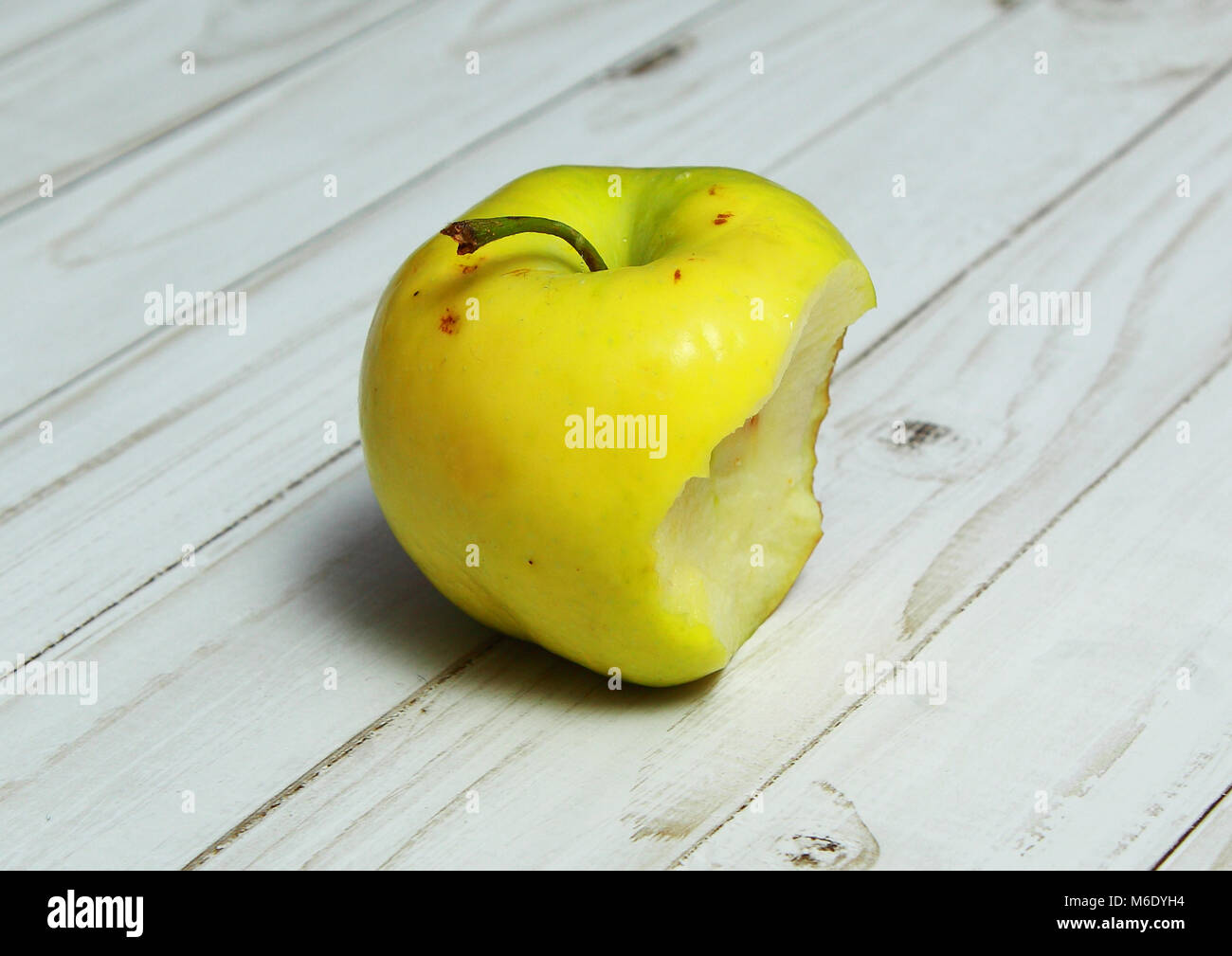 Yellow Apple with the missing piece. A bit like the Apple logo. Stock Photo