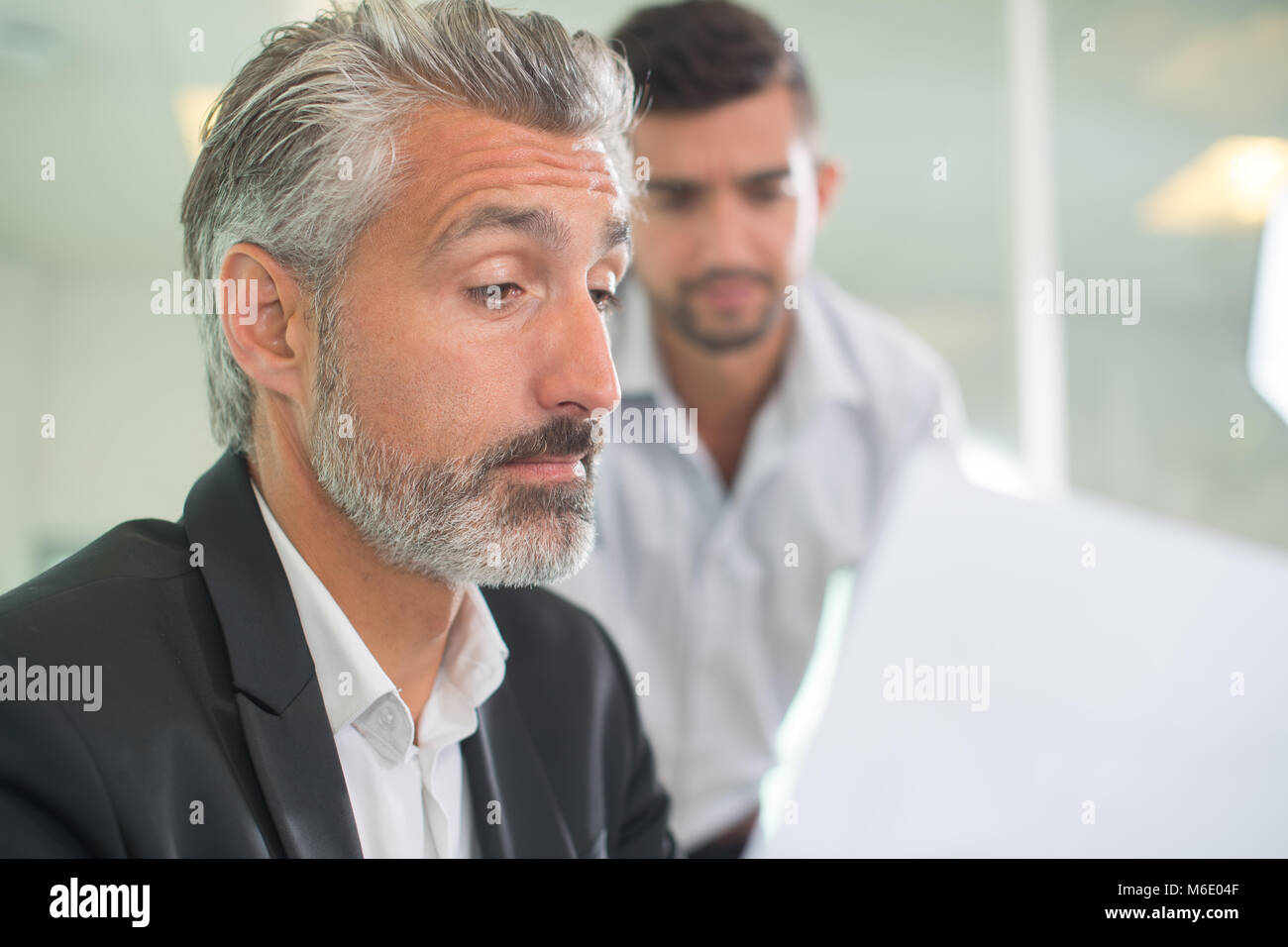 nervous man looking how the interviewer is reading his resume Stock Photo