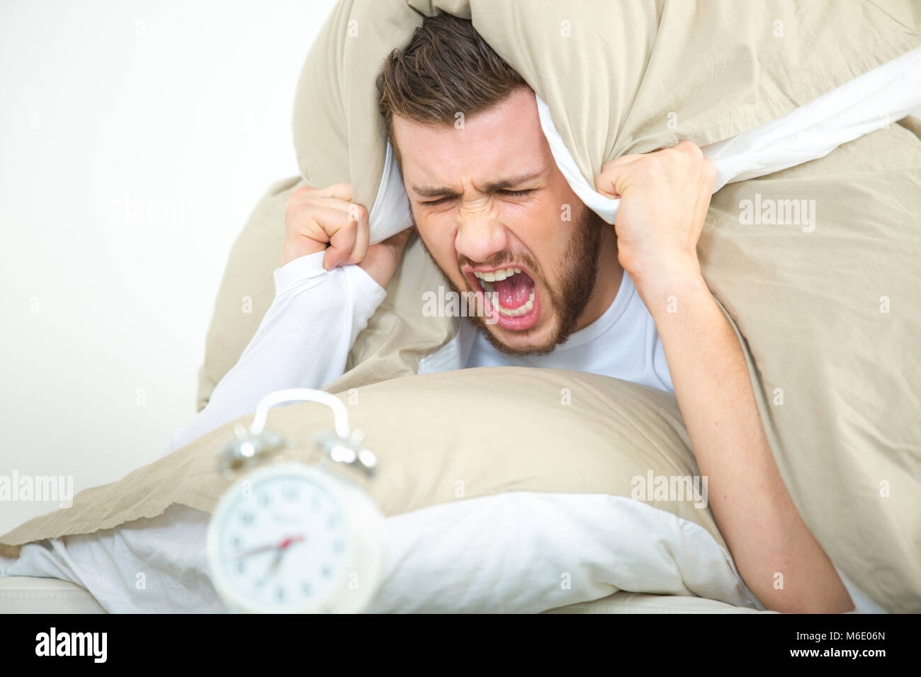 young angry man waking up Stock Photo - Alamy