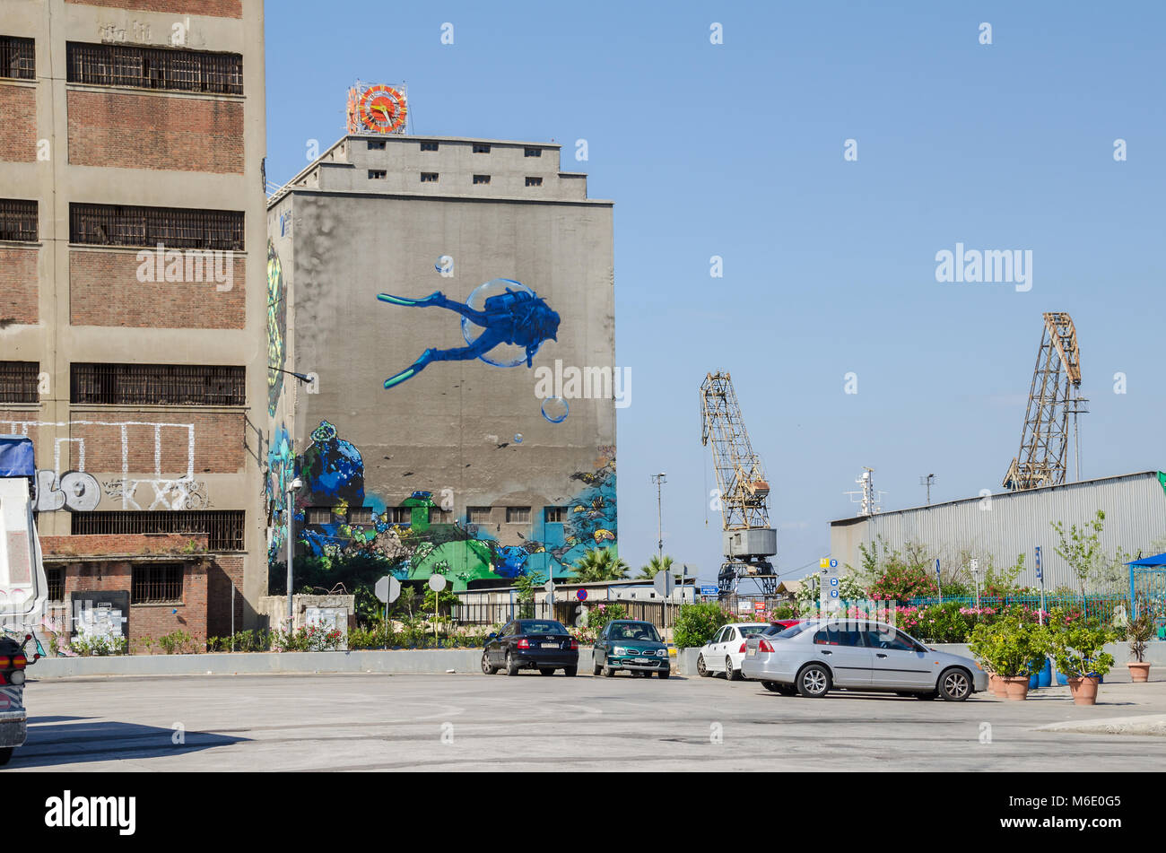 Port of Piraeus, Greece - Mai 30, 2017: Silo and dry docks  buildings with the wall painting near Silos Ietioneias Coast with its Floating Museum Stock Photo