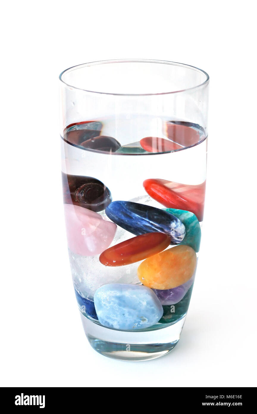 Crystal elixir – various kinds of crystals in full filled glass of water, making elixir Stock Photo
