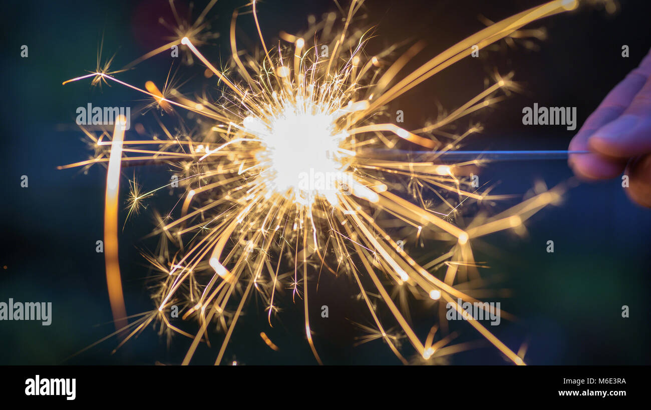 macro closeup of a person holding a sparkler at night Stock Photo