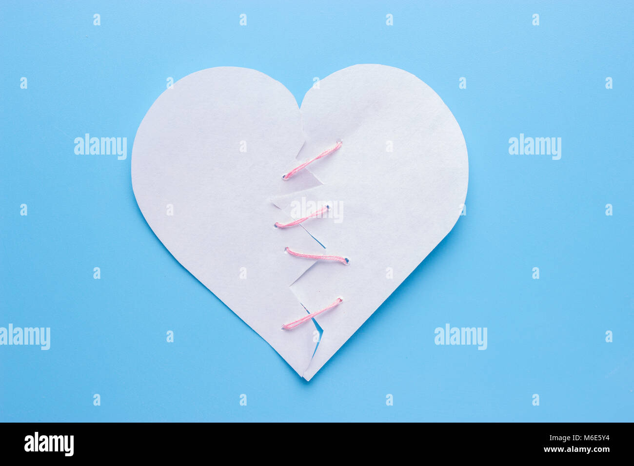 Healing broken heart. needle with pink thread Stock Photo Alamy