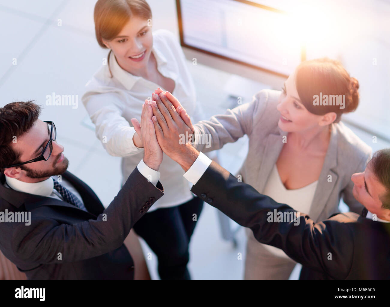 successful business team giving each other a high-five, standing in the ...