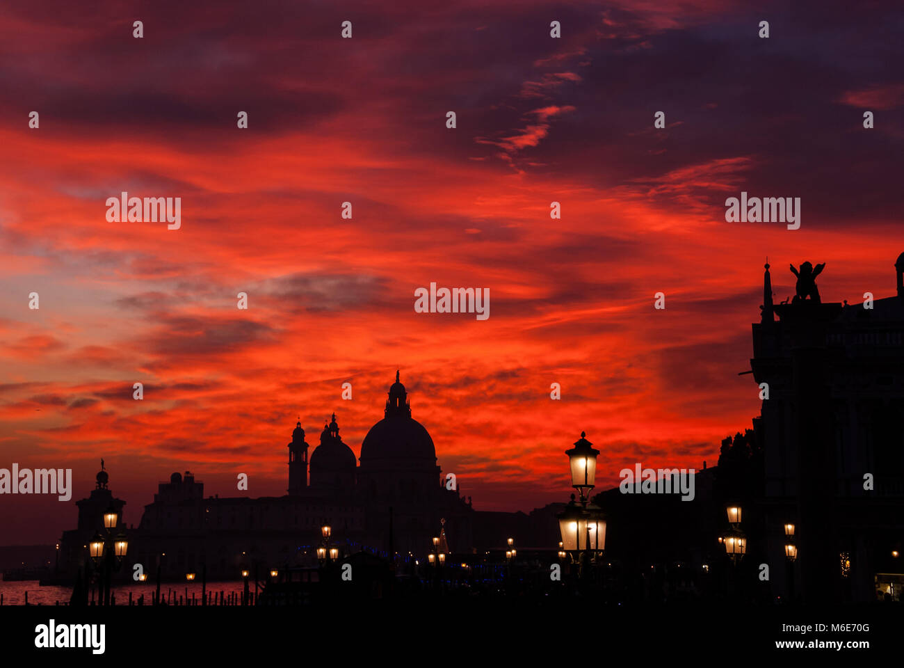 Red blood sky sunset over Venice Lagoon with Salute Basilica domes ...